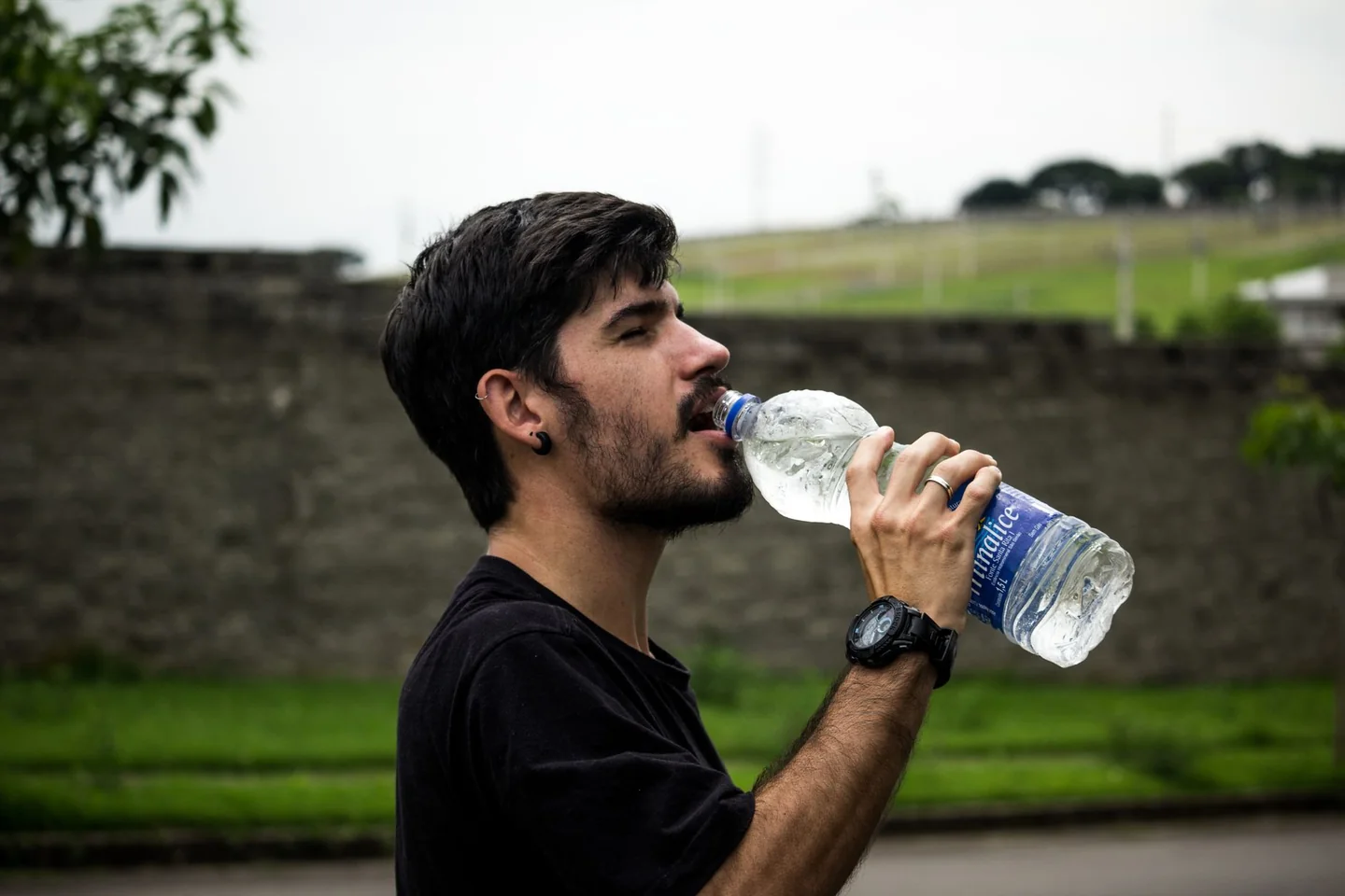 Imagen de un hombre bebiendo agua para ilustrar quanto bere quando fa caldo en una situación de calor y deshidratación.
