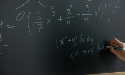 Profesor de matemáticas escribiendo una explicación sobre quali sono le proprietà delle potenze en la pizarra