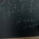 Profesor de matemáticas escribiendo una explicación sobre quali sono le proprietà delle potenze en la pizarra