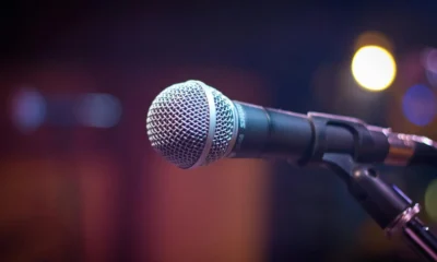 Imagen de un micrófono sobre un escenario para ilustrar chi è il cantante più ricco d italia