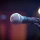 Imagen de un micrófono sobre un escenario para ilustrar chi è il cantante più ricco d italia