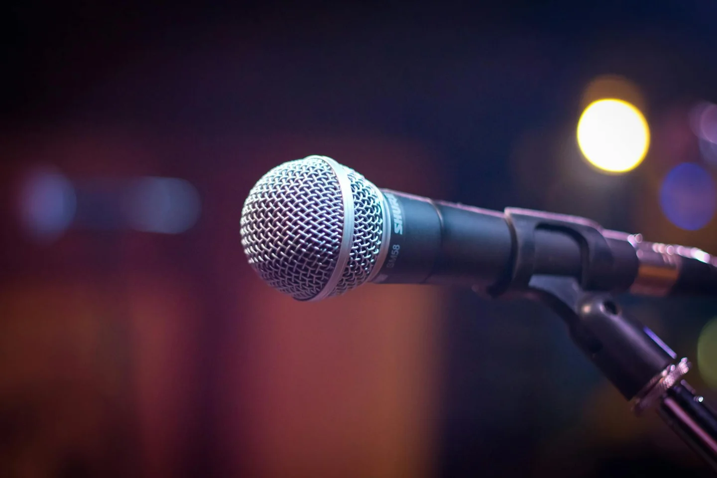 Imagen de un micrófono sobre un escenario para ilustrar chi è il cantante più ricco d italia
