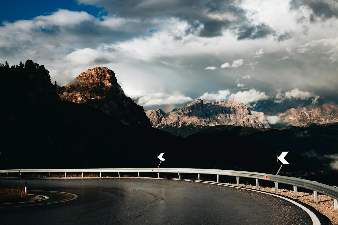 Curva de carretera de montaña sobre chi ha la precedenza in salita, ideal para ilustrar una estrechez real en pendiente.