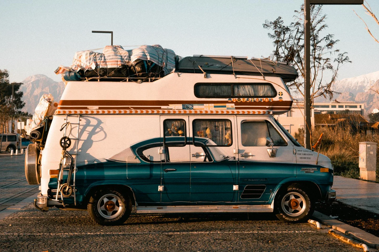 Un camper aparcado en la calle frente a una casa, ilustrando la duda "posso parcheggiare il camper sotto casa".
