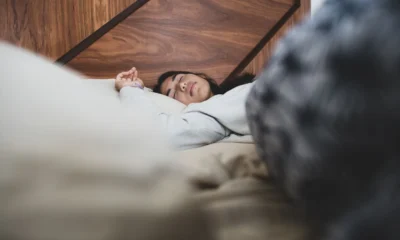 Persona durmiendo con ventilador encendido para ilustrar si può dormire con ventilatore acceso en un dormitorio caluroso