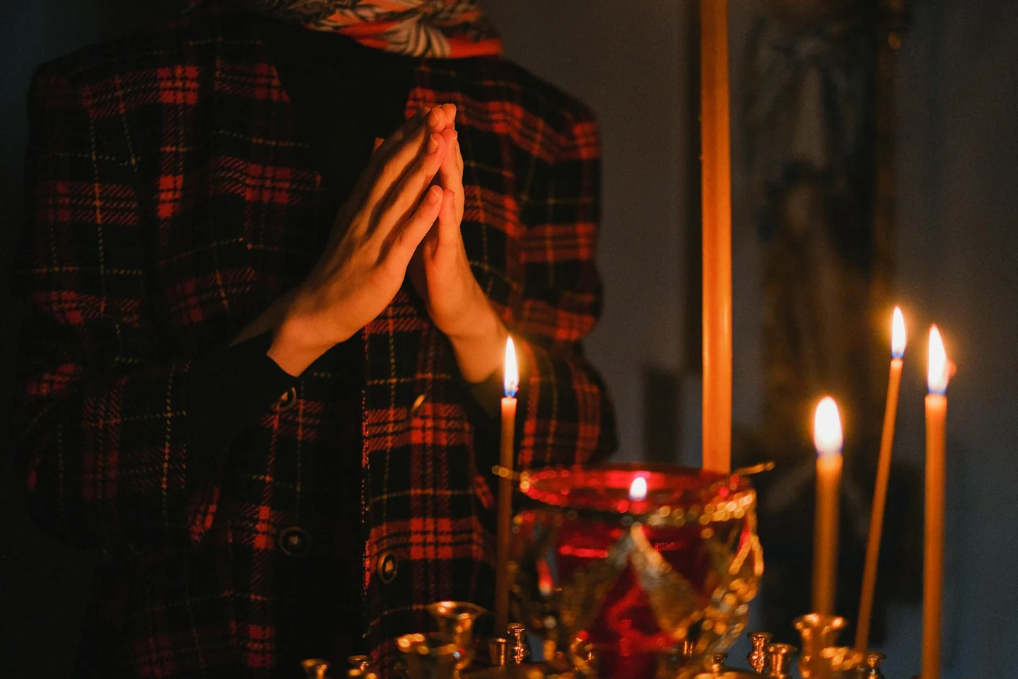 Imagen de manos en oración junto a una vela, evocando perche la vostra gioia sia piena en un contexto de recogimiento espiritual.