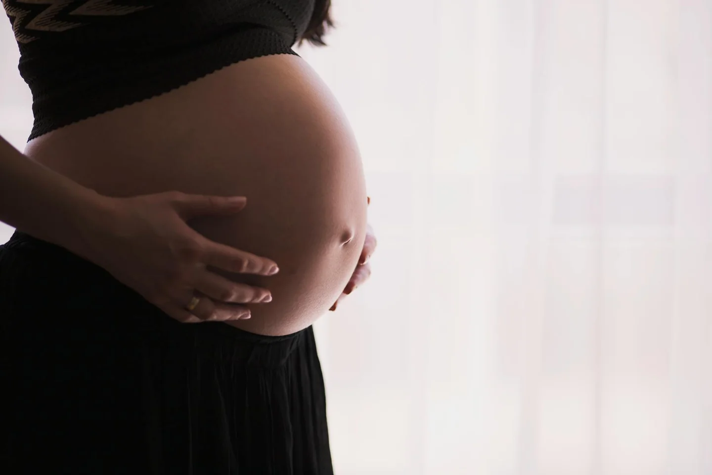 Fotografía de una mujer embarazada tocándose la barriga, ideal para ilustrar cuándo se siente el bambino muoversi.