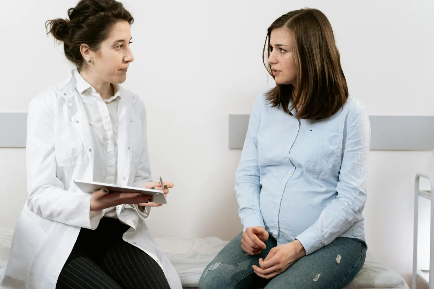 Pregnant woman doctor para ilustrar quando inizia l'ottavo mese di gravidanza en una revisión médica del tercer trimestre