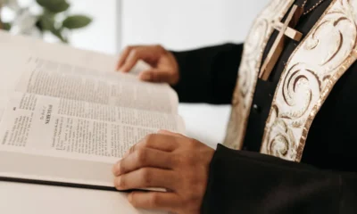 Un sacerdote sosteniendo dinero como imagen de apoyo para el artículo chi paga lo stipendio di un prete en Italia