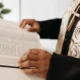 Un sacerdote sosteniendo dinero como imagen de apoyo para el artículo chi paga lo stipendio di un prete en Italia