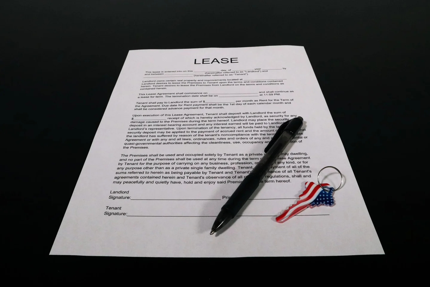 Persona firmando un documento de alquiler para ilustrar a chi conviene intestare il contratto di affitto en un contexto de contrato de arrendamiento y responsabilidad compartida.