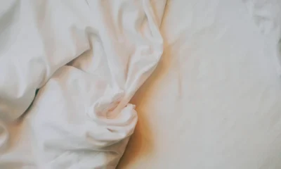 Persona cosiendo un lenzuolo para come fare gli angoli alle lenzuola en una mesa de trabajo