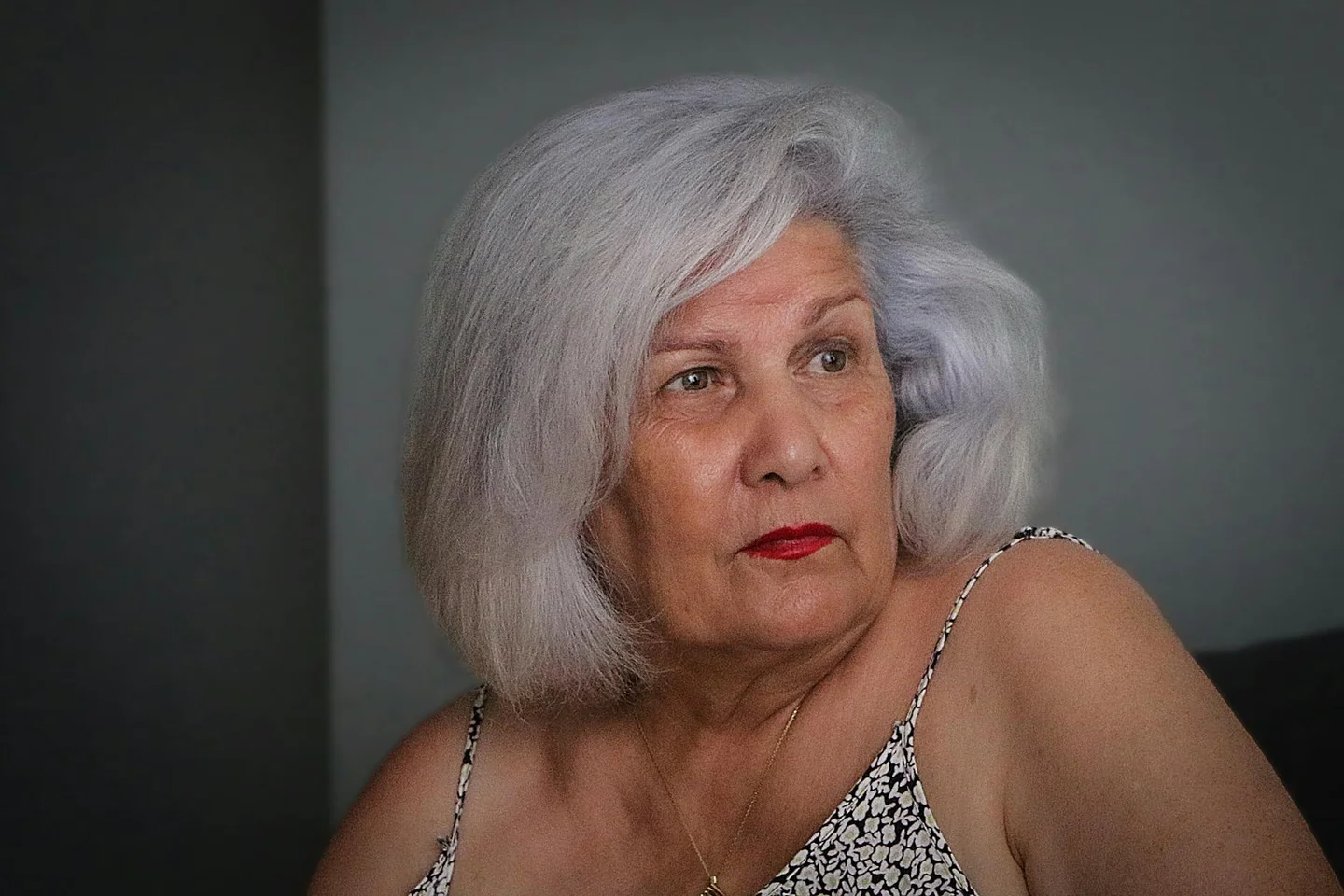 Retrato de una persona con a chi stanno bene i capelli sale e pepe, mostrando cabello plateado y rasgos faciales definidos.