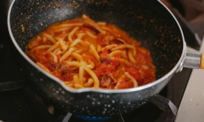 Una olla con salsa de tomate a fuego lento para ilustrar "quanto deve cuocere la passata di pomodoro" en una cocina casera.