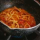 Una olla con salsa de tomate a fuego lento para ilustrar "quanto deve cuocere la passata di pomodoro" en una cocina casera.