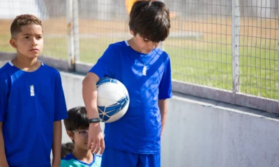 Imagen de stock sobre perché i calciatori entrano in campo con i bambini, con jugadores de fútbol y niños caminando juntos hacia el campo antes del partido.