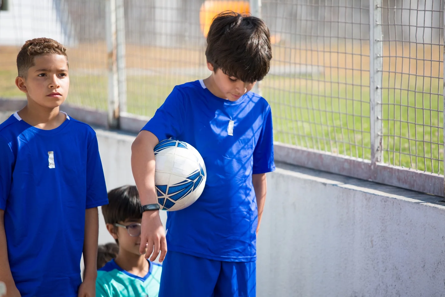 Imagen de stock sobre perché i calciatori entrano in campo con i bambini, con jugadores de fútbol y niños caminando juntos hacia el campo antes del partido.