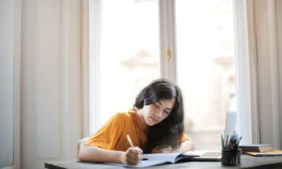 Estudiante escribiendo un texto para come iniziare un tema di italiano en un cuaderno escolar