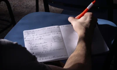 Estudiante tomando notas sobre come citare una rivista in una tesi para organizar la bibliografía de un trabajo académico.