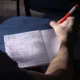 Estudiante tomando notas sobre come citare una rivista in una tesi para organizar la bibliografía de un trabajo académico.