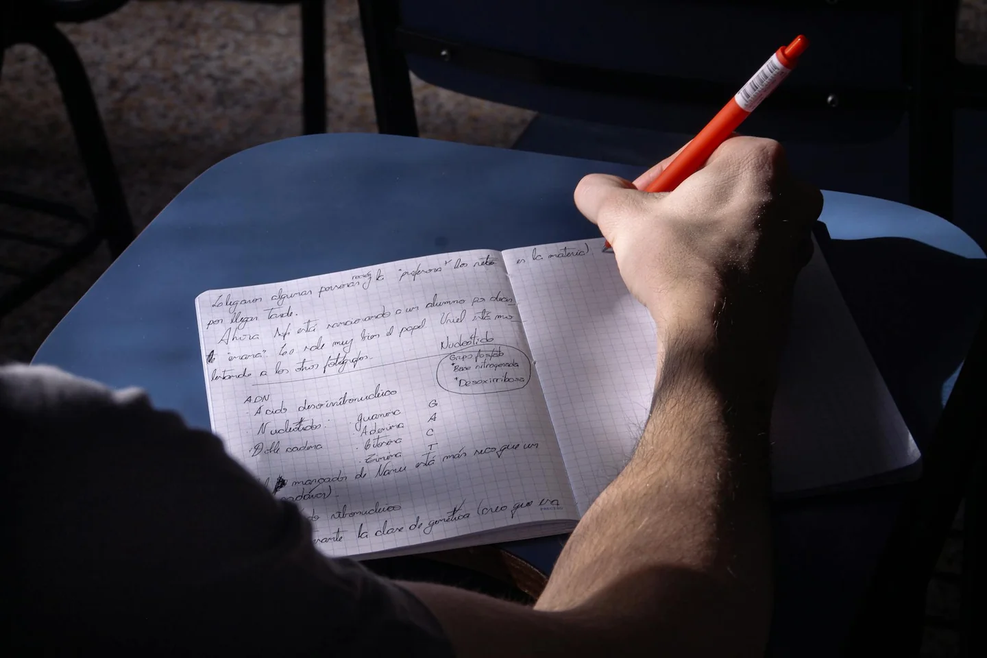 Estudiante tomando notas sobre come citare una rivista in una tesi para organizar la bibliografía de un trabajo académico.