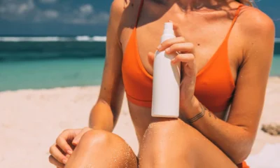 Mujer con la piel enrojecida por el sol en la playa, imagen relacionada con "si può prendere il sole con un antibiotico" y las precauciones ante la fotosensibilidad.