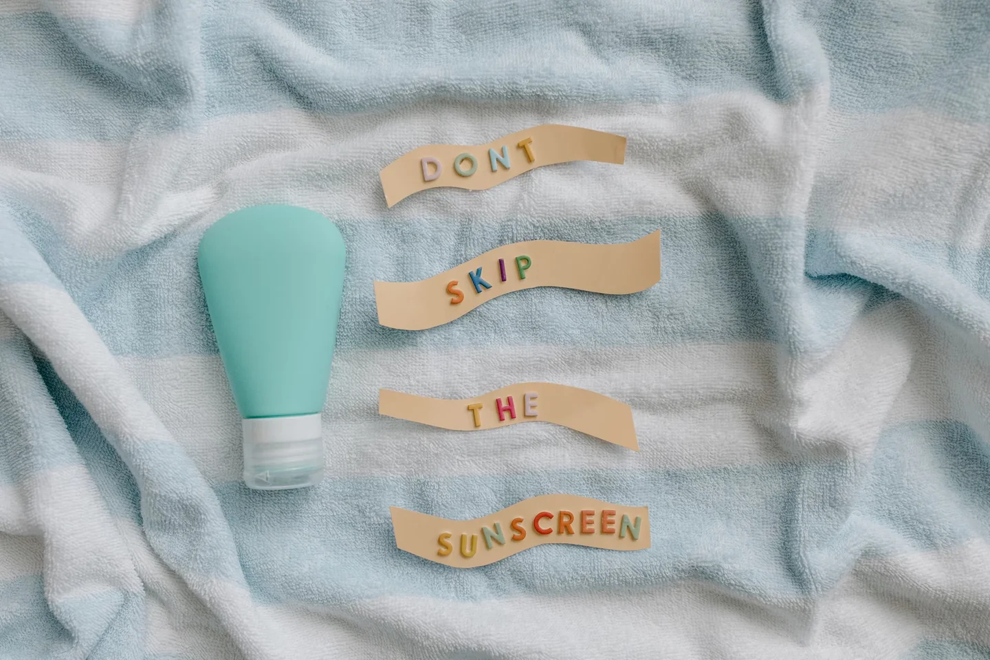Botella de crema solar en la playa para ilustrar si può usare una crema solare scaduta