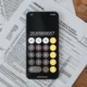 Documento fiscal con calculadora para ilustrar perché il 730 risulta a debito en un artículo sobre el conguaglio del 730.
