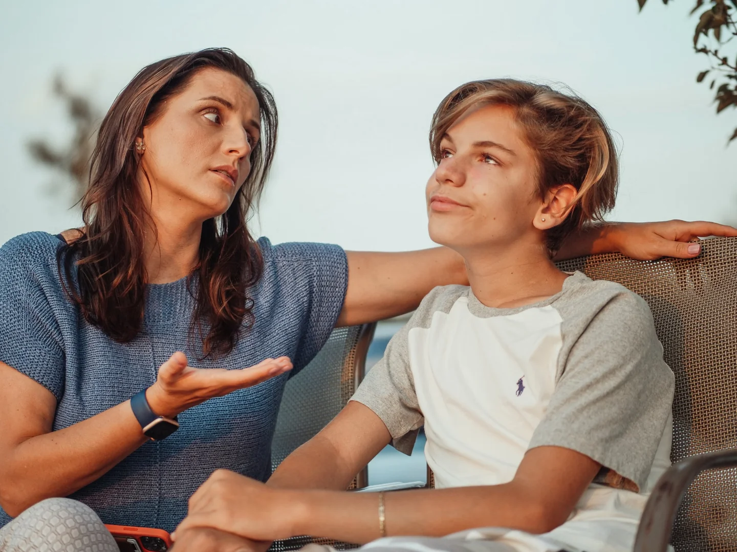 Conversación visual entre padre e hijo para ilustrar domande da fare a un figlio adolescente en un contexto de diálogo familiar cercano.