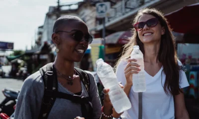 Una persona con una travel water bottle para ilustrar dove trovare acqua potabile in viaggio en un contexto de viaje y refill.