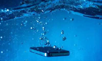 Imagen para explicar cosa fare se il telefono cade in acqua con un smartphone mojado sobre una superficie seca.