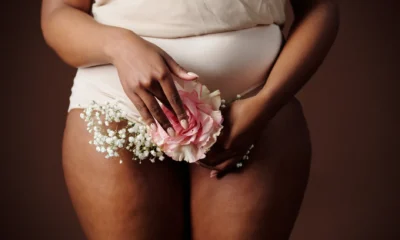 Mujer sosteniéndose el abdomen por dolor, ilustrando "dove si trova la bocca dello stomaco" en una zona alta del vientre.